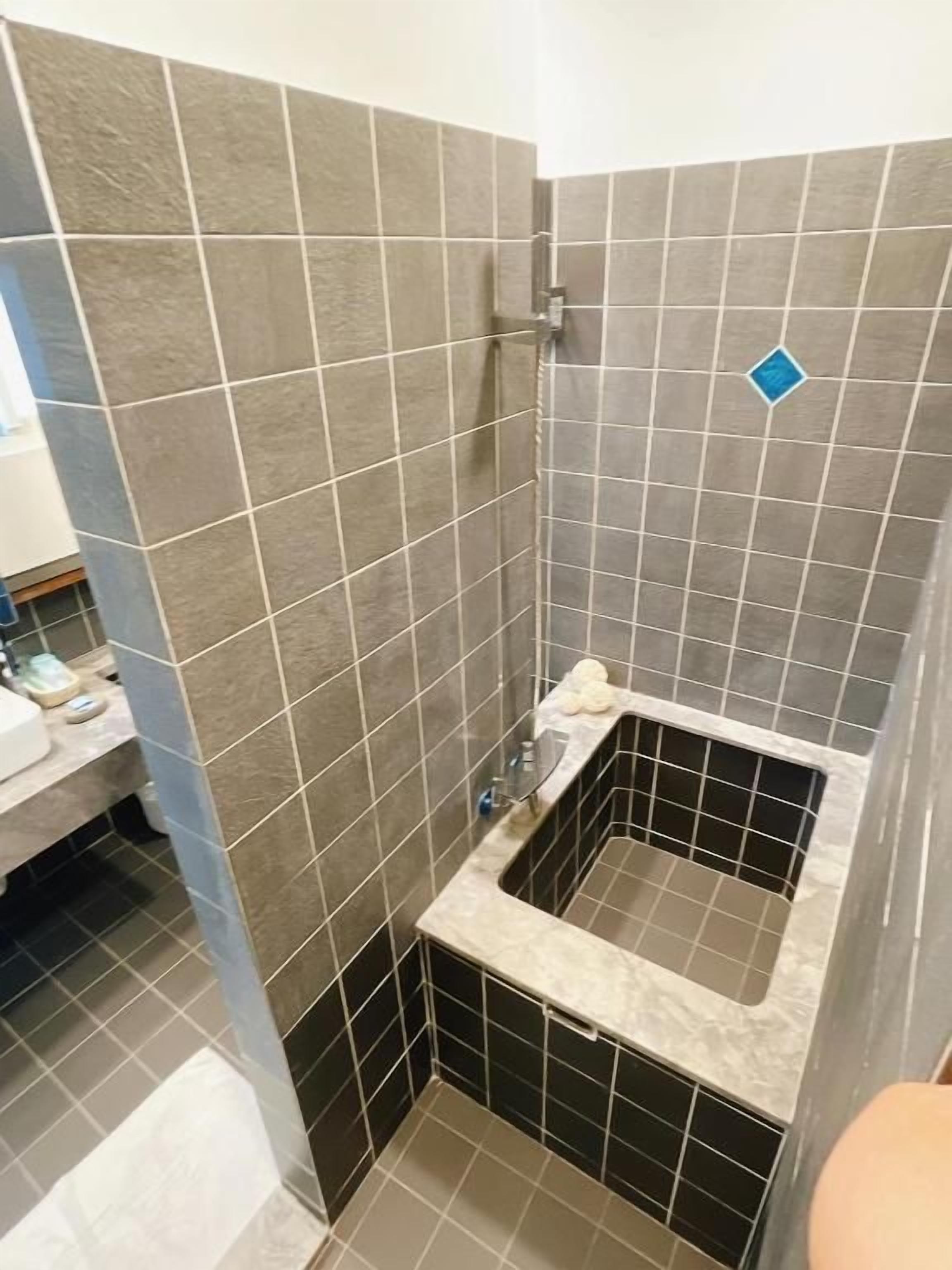 A bathroom with a shower, a sink, and a toilet.