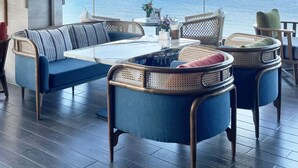 A modern lounge with a view of the sea, featuring a sofa, two armchairs, and a coffee table. - Queen Ann Nha Trang (Nha Trang)