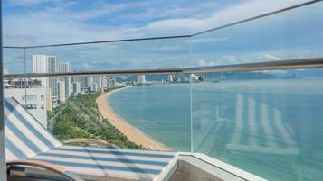 A balcony with a view of a beach and cityscape.