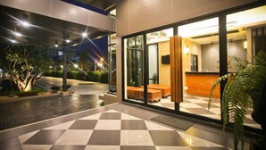 A modern hotel lobby with a checkered floor, glass doors, and a reception desk. - Bunprasop Garden Hotel (Nakhon Si Thammarat)