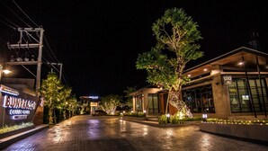 A well-lit hotel entrance at night with a paved walkway, illuminated trees, and a sign for "BUNYASOR". - Bunprasop Garden Hotel (Nakhon Si Thammarat)