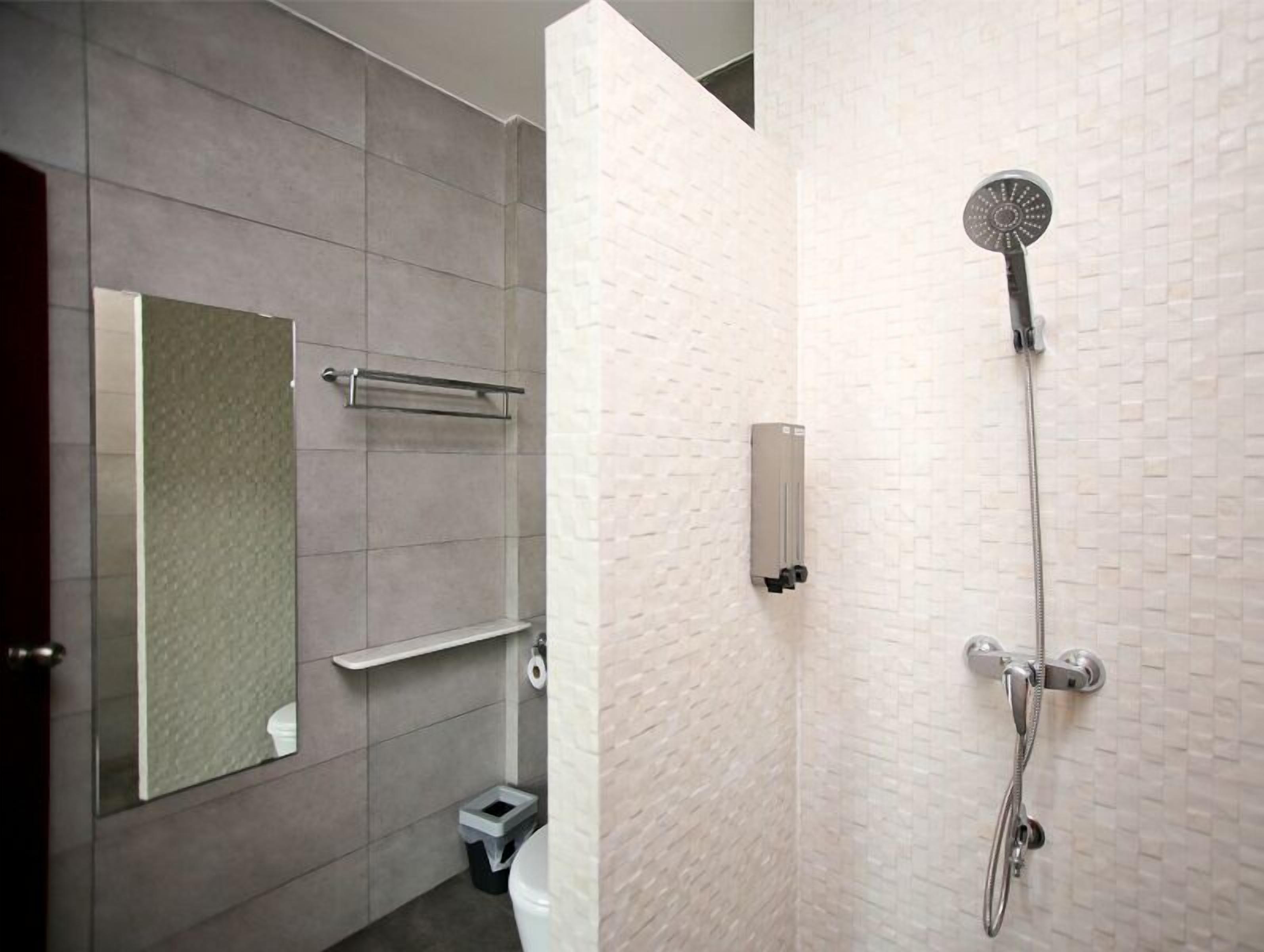 A modern bathroom with a shower, toilet, and a towel rack.