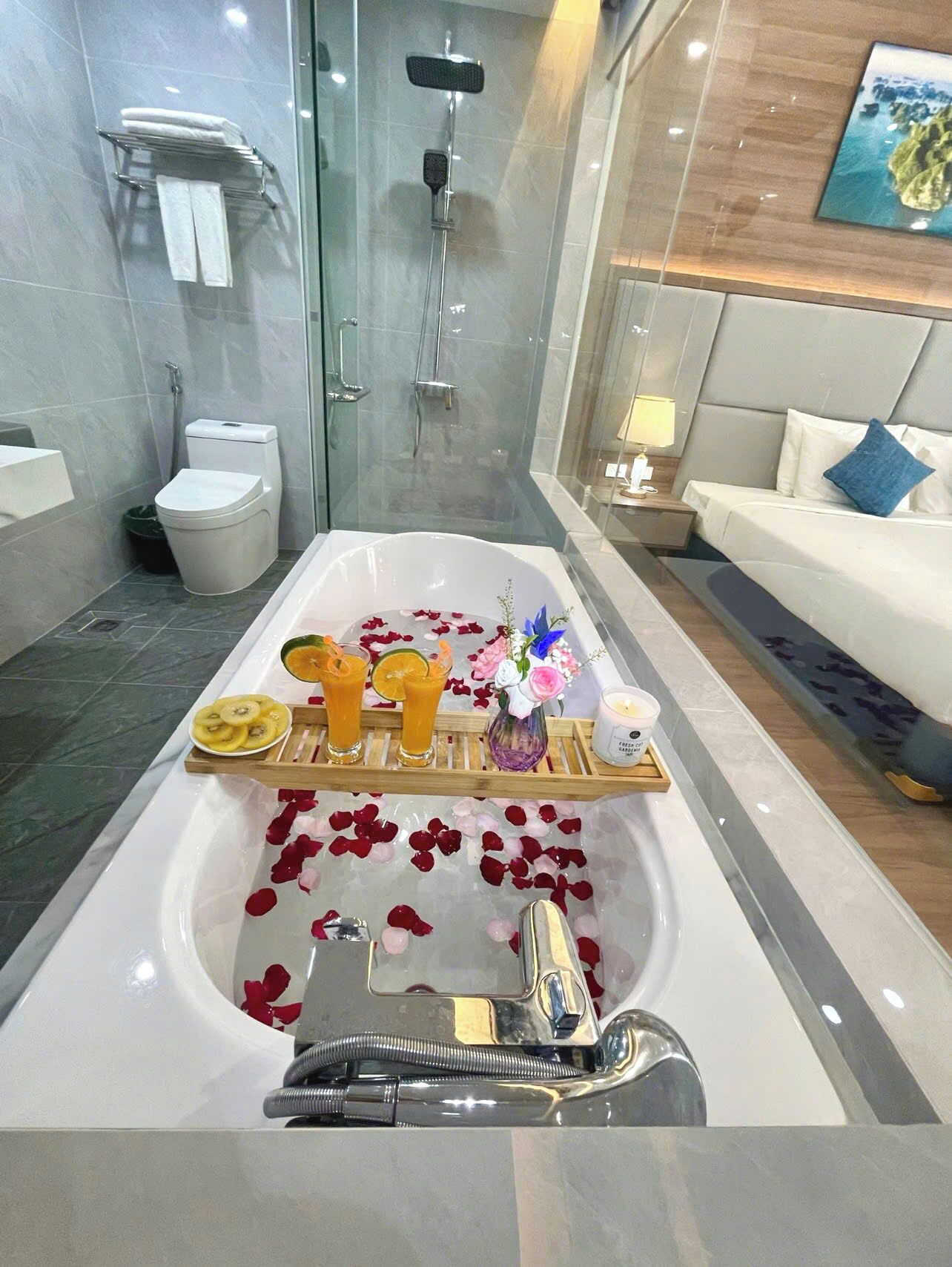 A modern bathroom with a bathtub, shower, and toilet.