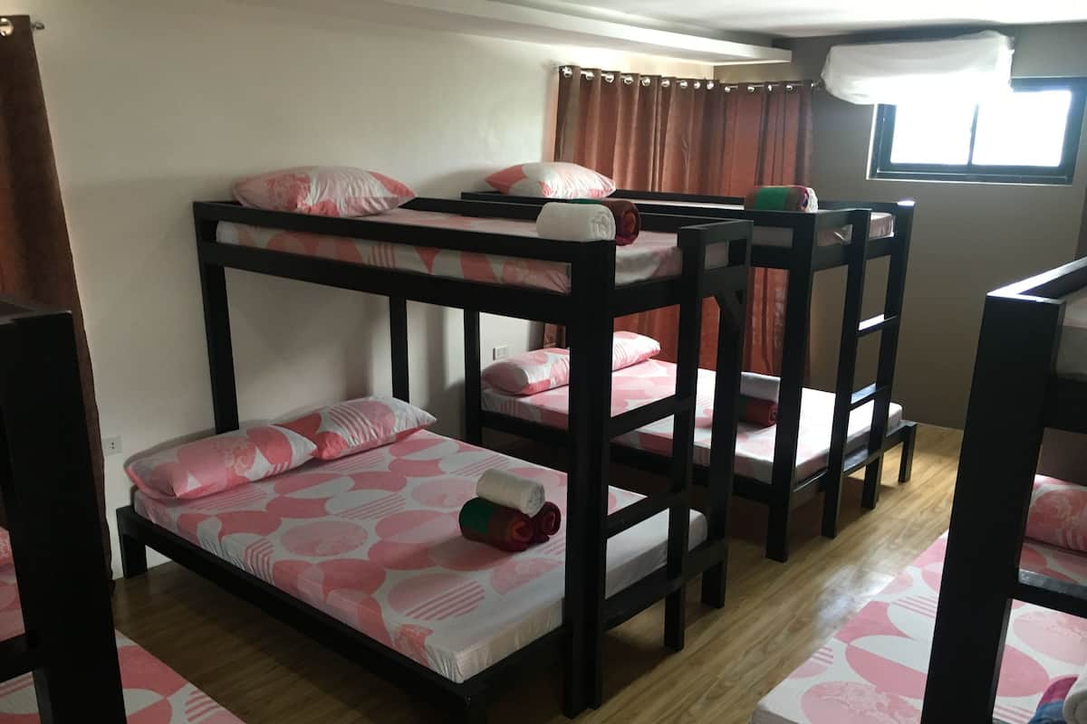 A bunk bed room with a window and curtains.