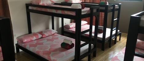 A bunk bed room with a window and curtains.