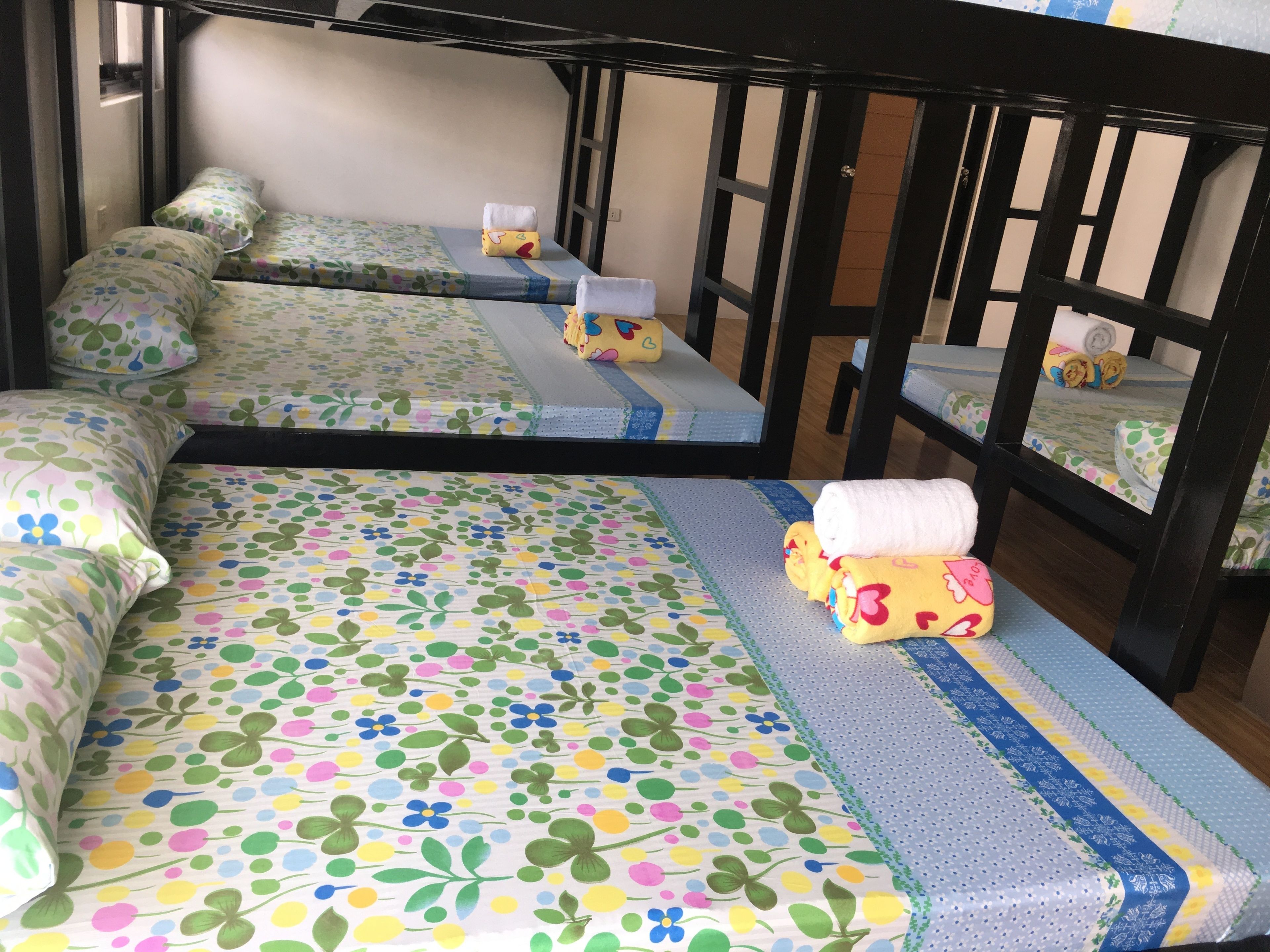 A bunk bed with floral bedding and a small table with a yellow plush toy.