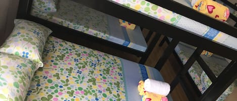 A bunk bed with floral-patterned bedding and a rolled-up towel on the lower bunk.