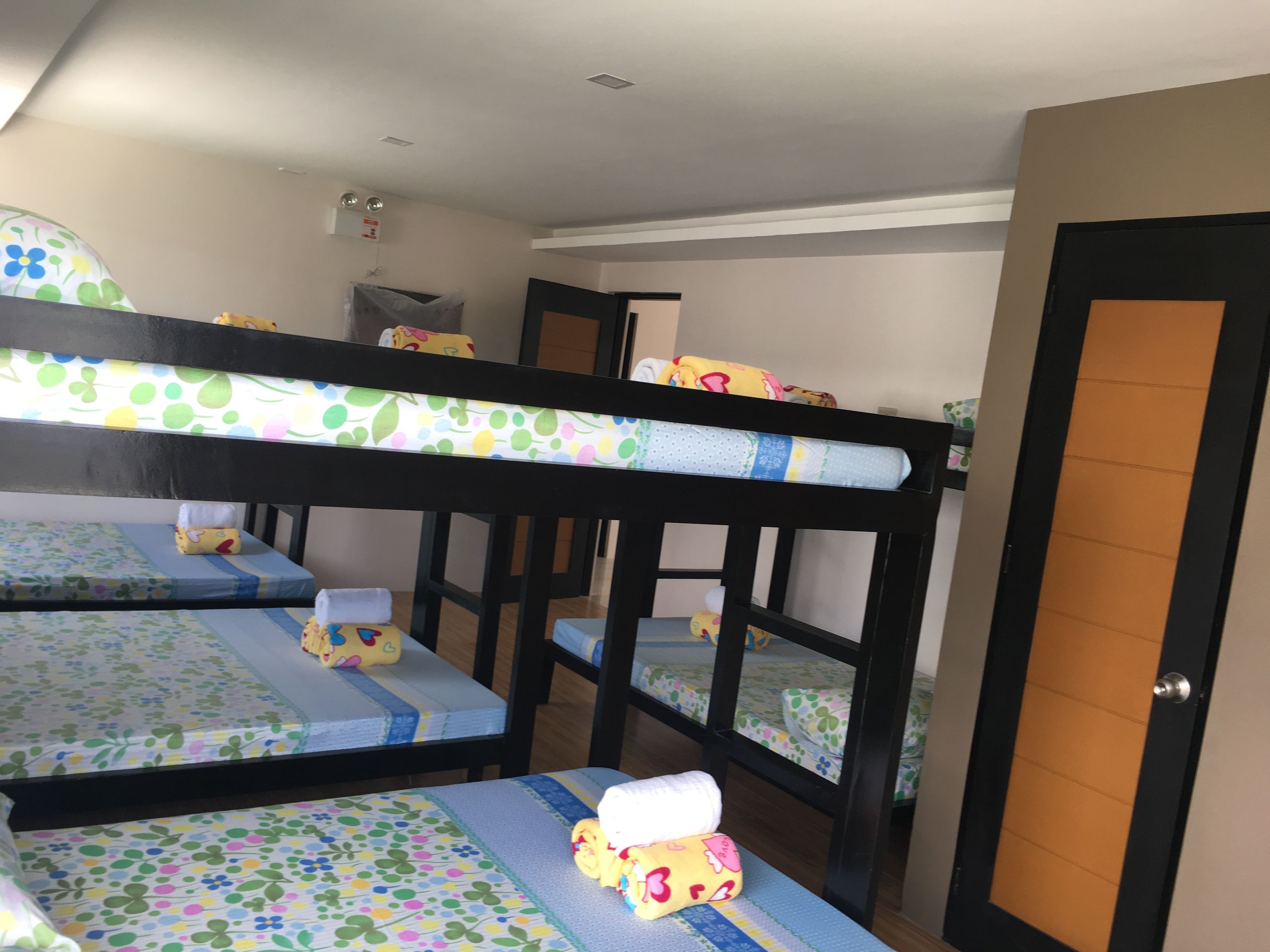 Quarto com beliches, cada um com colchão e almofadas estampados com motivos florais.