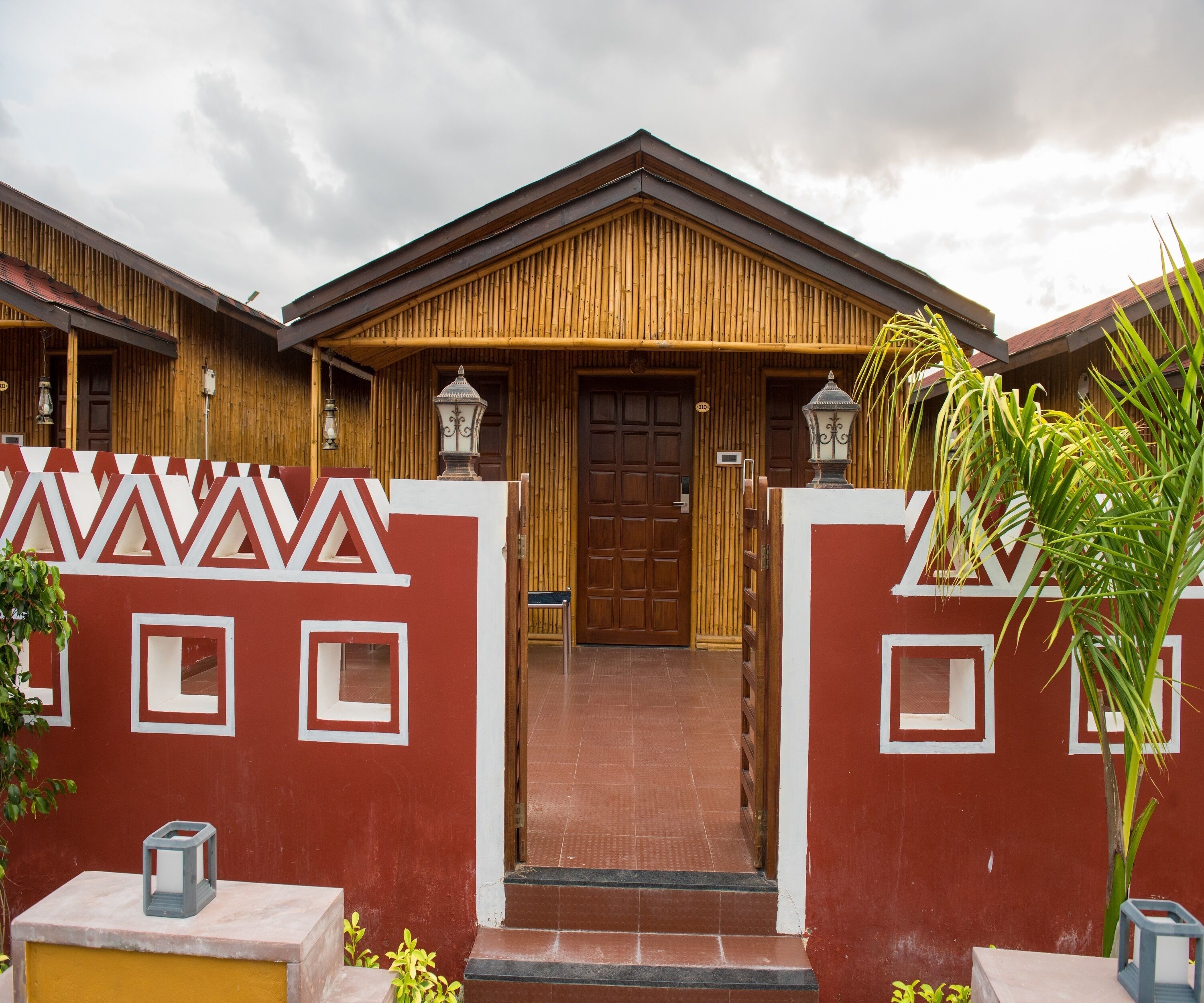 A hotel entrance with a wooden facade, a red and white decorative wall, and a tiled entrance.