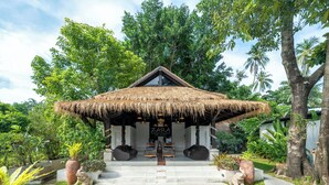Une construction à toit de chaume sur laquelle est apposée une enseigne indiquant « ZARA Beach Resort ».