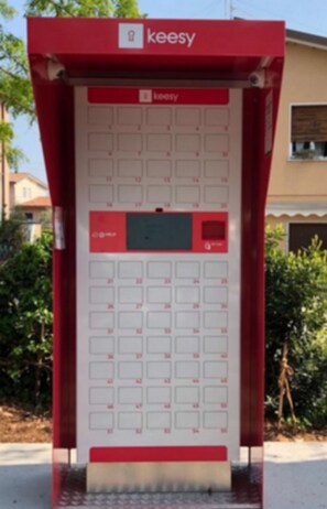A red and white kiosk with multiple service windows, labeled "keesy," likely for a vending or ticketing service. - Desenzanoloft – Garden and Pool - Casa Annamaria (Desenzano del Garda)
