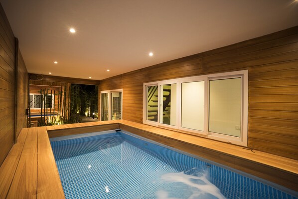 A modern indoor swimming pool with wooden walls and glass doors. - The M Pool Villas Bangkok - BTS Ekkamai (Bangkok)