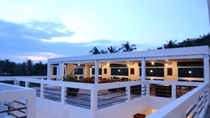 A multi-level building with a balcony and indoor seating area. - Diva Lombok Resort (Senggigi)