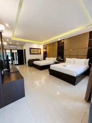 A modern hotel room with two beds, a desk, and a large artwork on the wall. - Diva Lombok Resort (Senggigi)