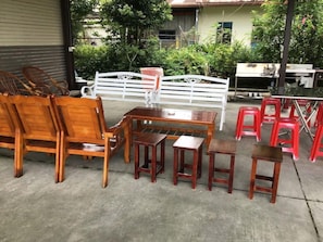 Un patio con muebles de madera y sillas de plástico rojo.