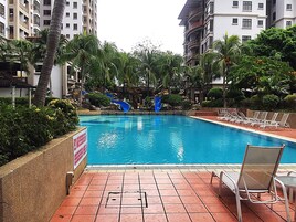 Una piscina al aire libre, sillones reclinables de piscina