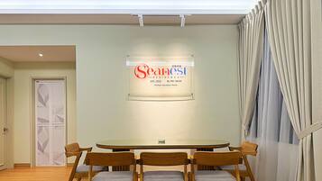 A conference room with a round table, six wooden chairs, and a sign on the wall.