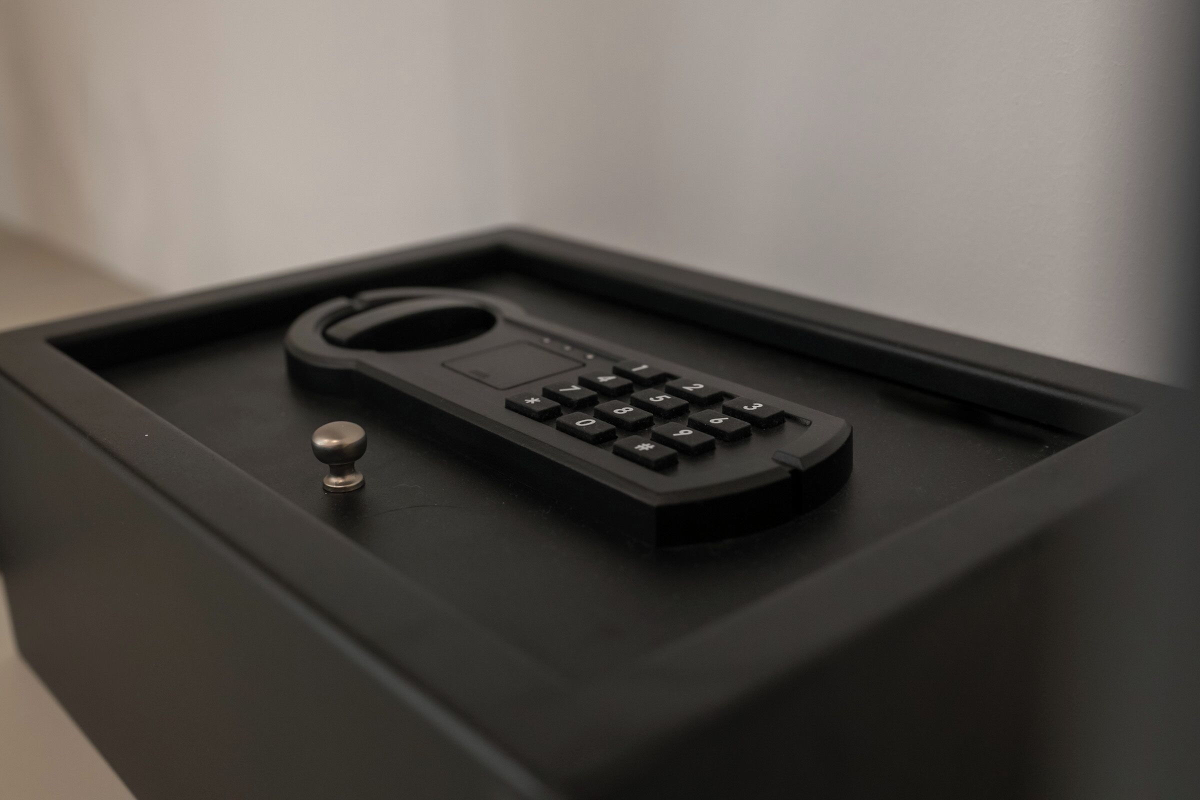 A black electronic device, possibly a remote control, on a black surface.