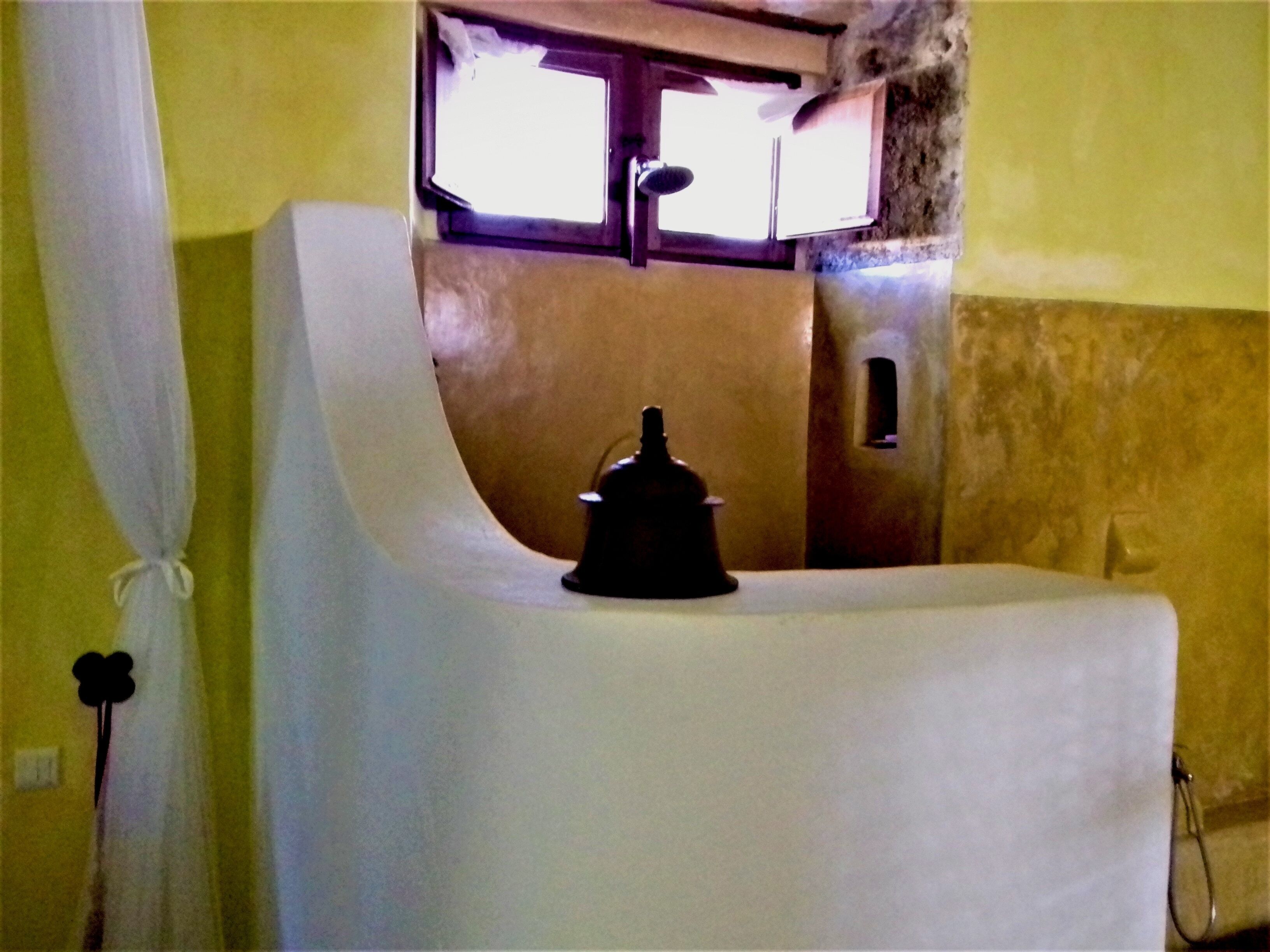 A bathroom with a bathtub, a window, and a shower curtain.