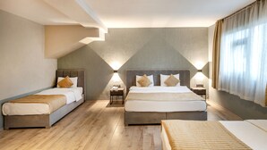 A hotel room with two beds, a small table, and a lamp. - Orya Hotel (Istanbul)