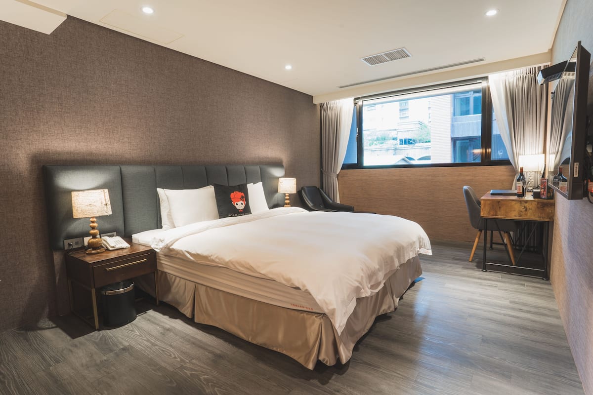 Una habitación de hotel moderna con una cama grande, un escritorio y una silla.