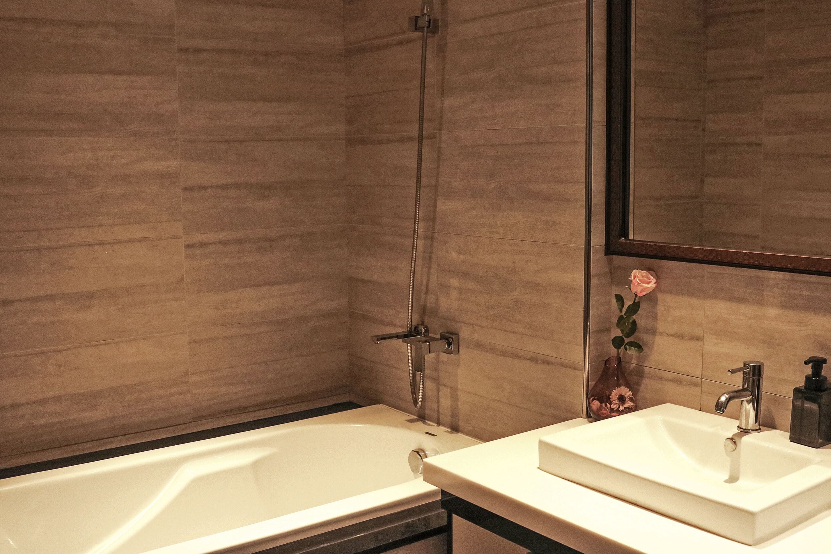 A modern bathroom with a bathtub, a sink, and a mirror.