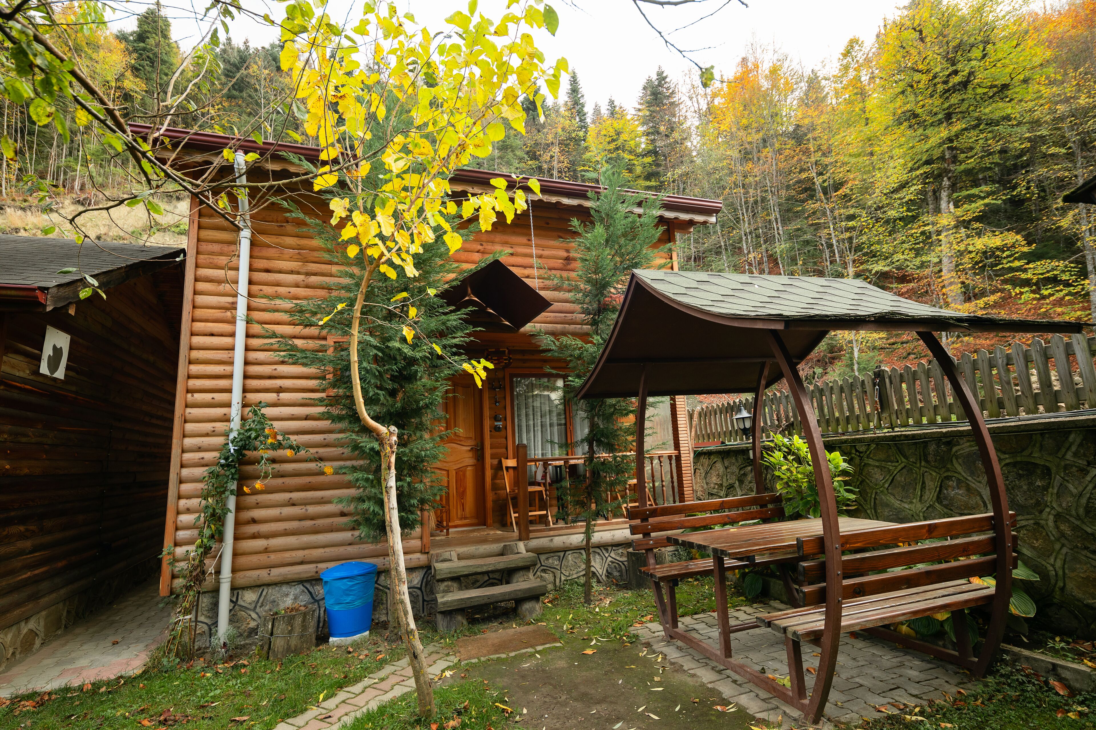 Une cabane rustique avec une véranda en bois et un banc.