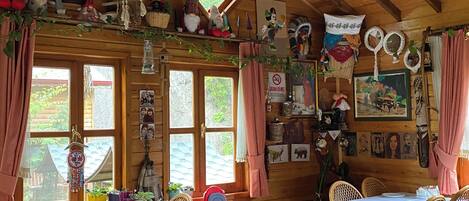 Un comedor acogedor y rústico con vigas de madera, sillas de mimbre y una mesa dispuesta para una comida.