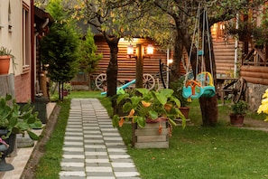 Stroll along the garden pathway to a charming cabin surrounded by lush greenery and natural beauty.
