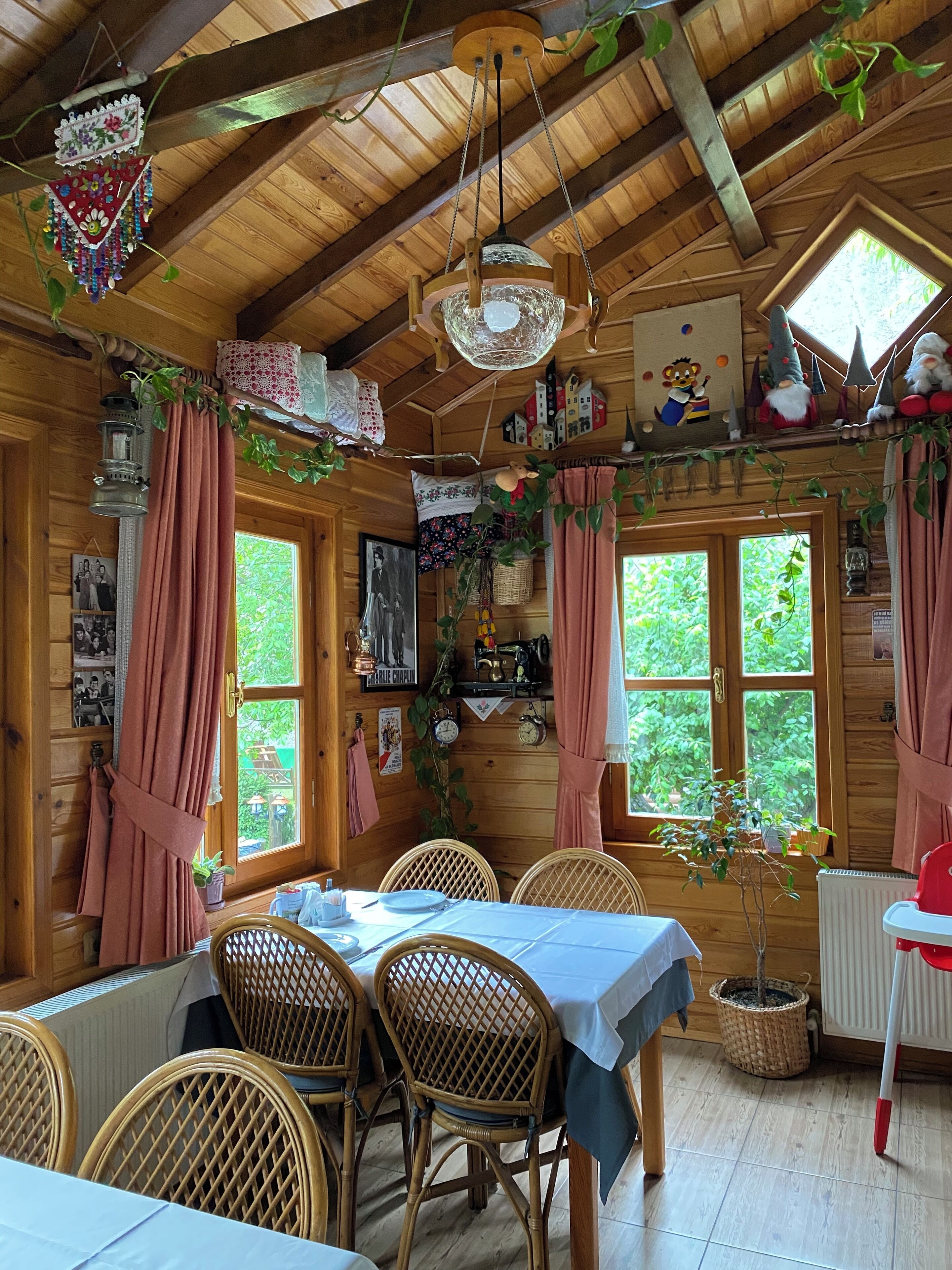A cozy wooden cabin with a dining area featuring wicker chairs and a table set for two.
