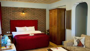 A room with a bed, a wooden wardrobe, a sofa, and a coffee table.