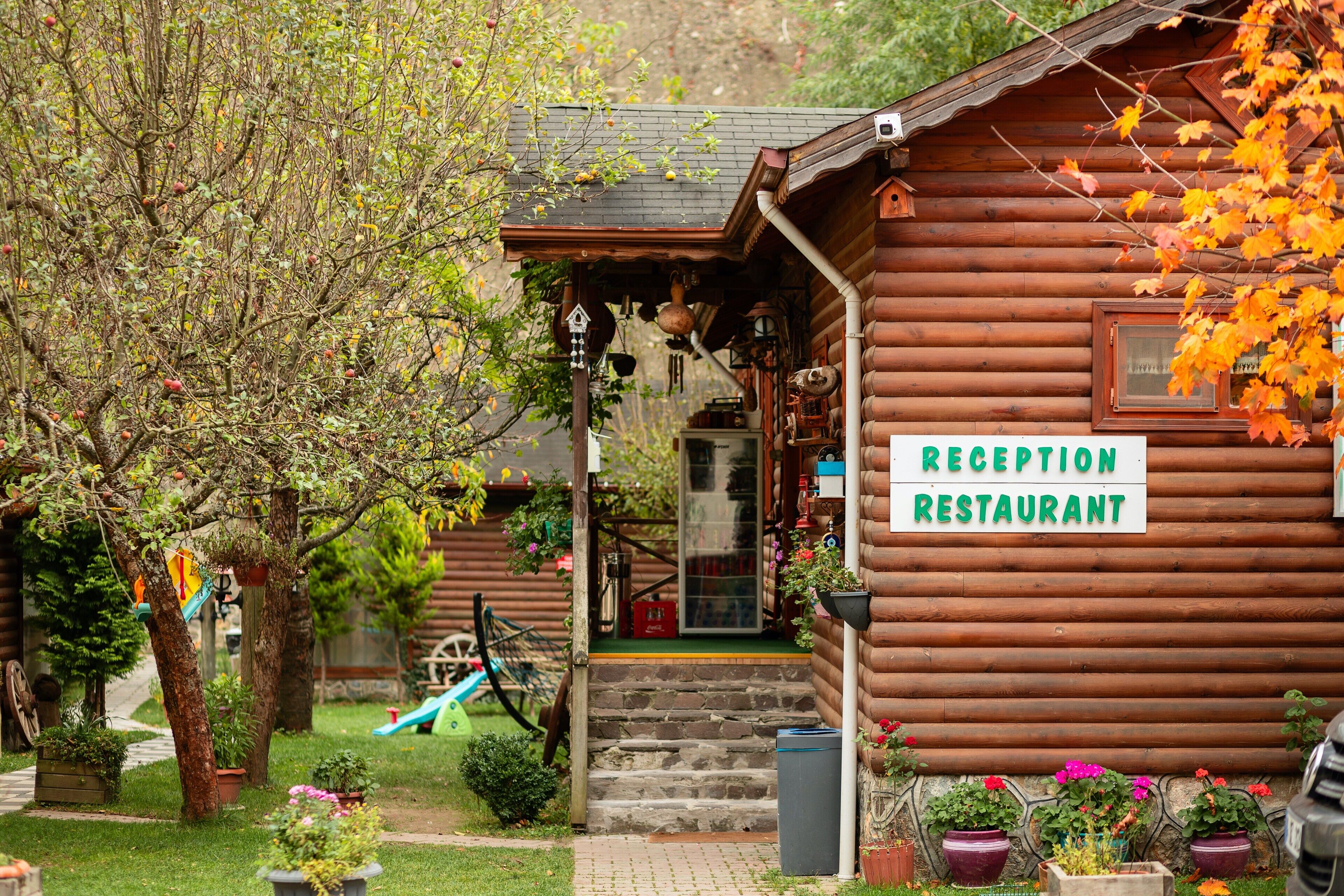 Una cabaña de madera con área de recepción y un letrero que indica que es un restaurante.