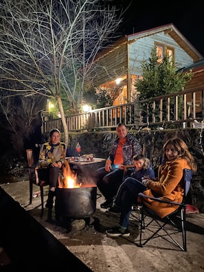 Relax in an outdoor space with a fire pit, surrounded by a deck and stone wall.