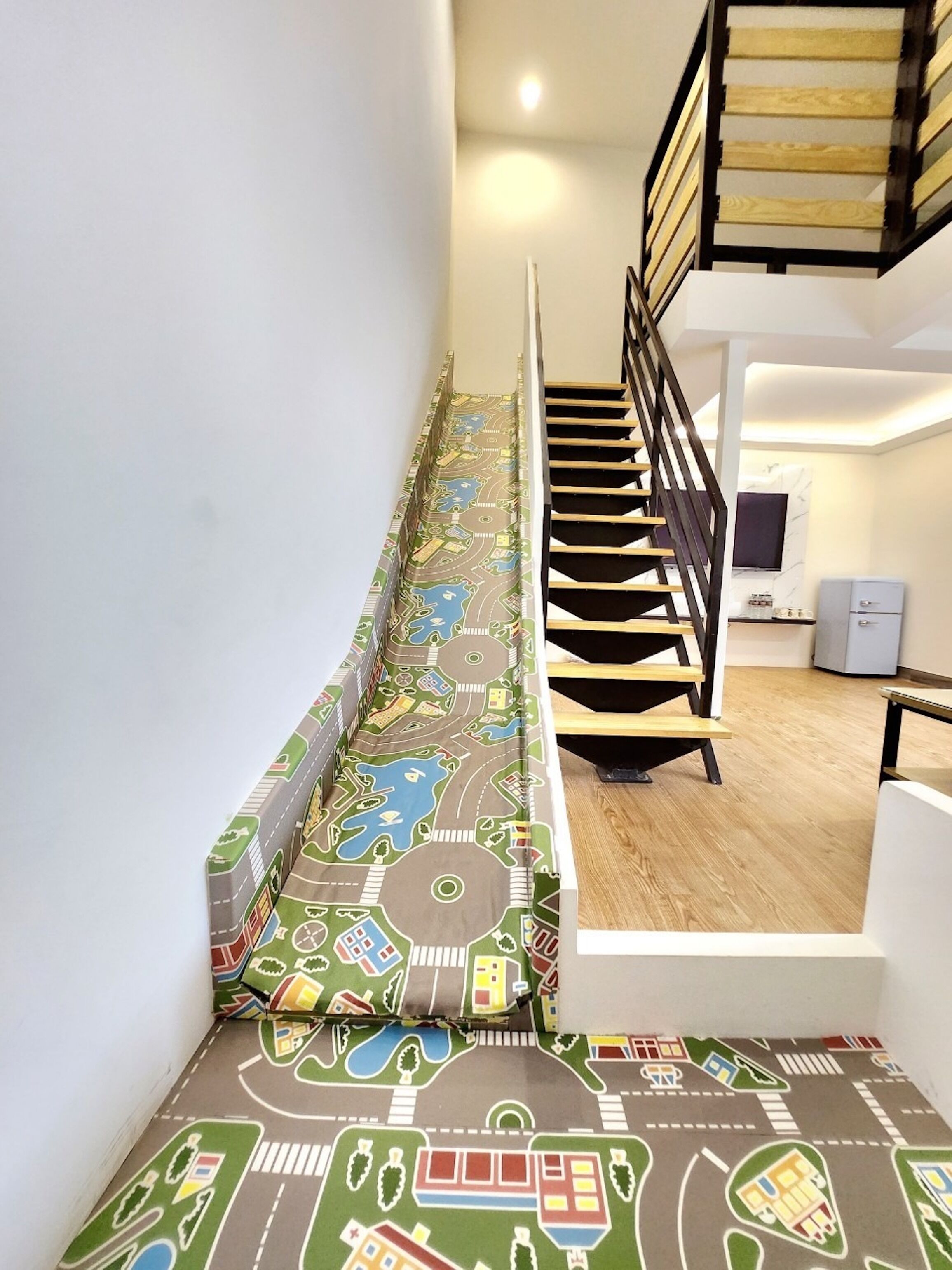 A staircase with a colorful, patterned carpet depicting a cityscape.