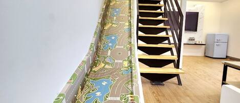 A staircase with a colorful, patterned carpet depicting a cityscape.