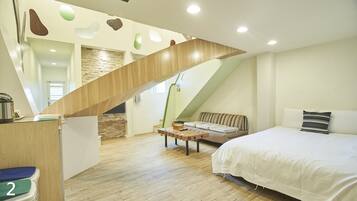 Un dormitorio moderno con una escalera de madera, una cama, un sofá y una pequeña mesa.