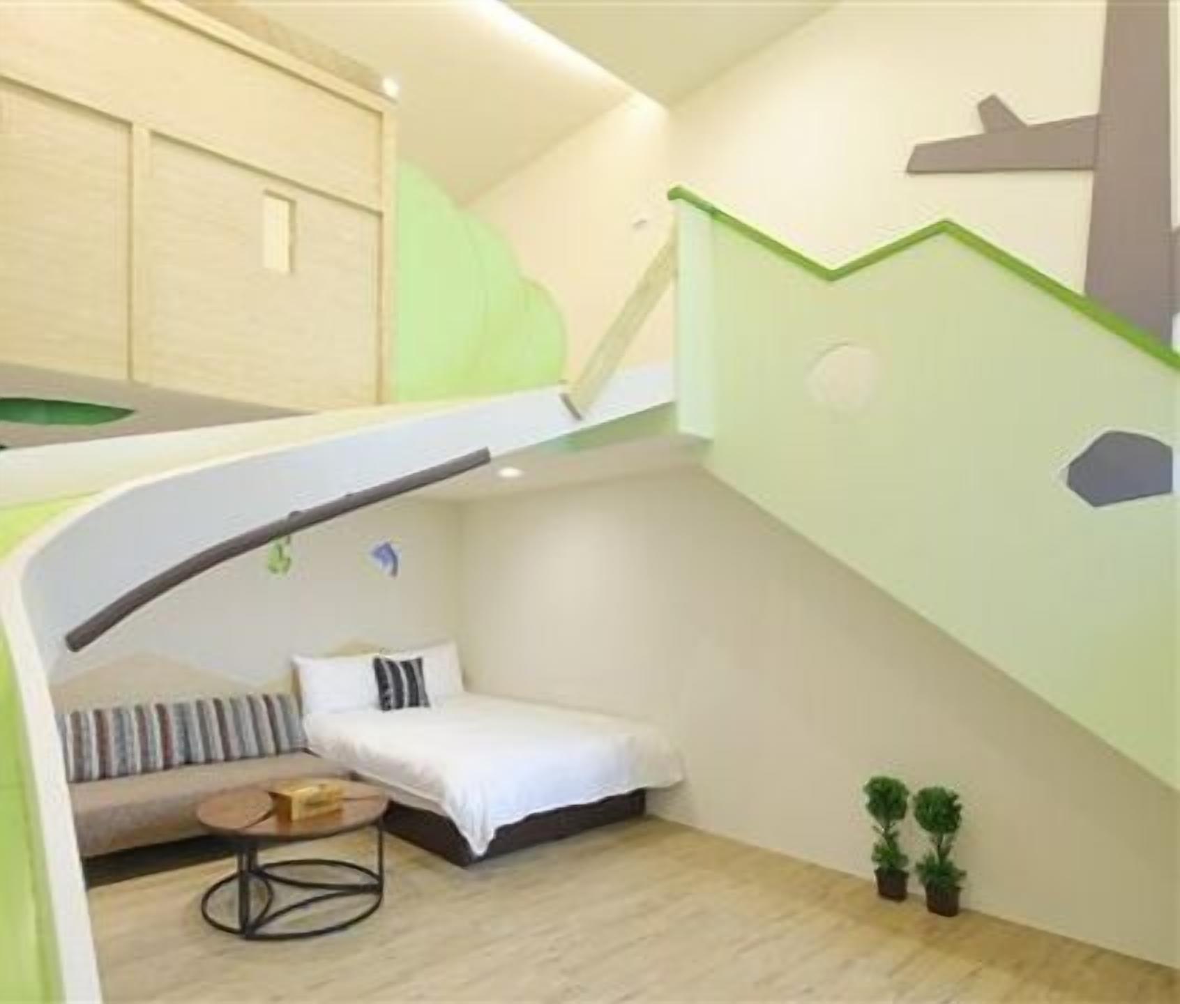 A compact, modern room with a bunk bed, a small sofa, and a round table.