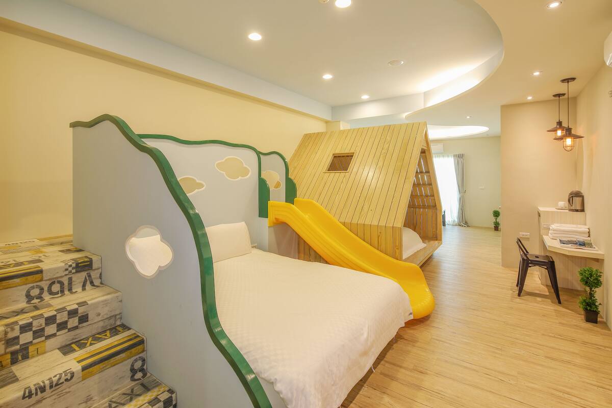 A children's playroom with a bed, a slide, and a play area.