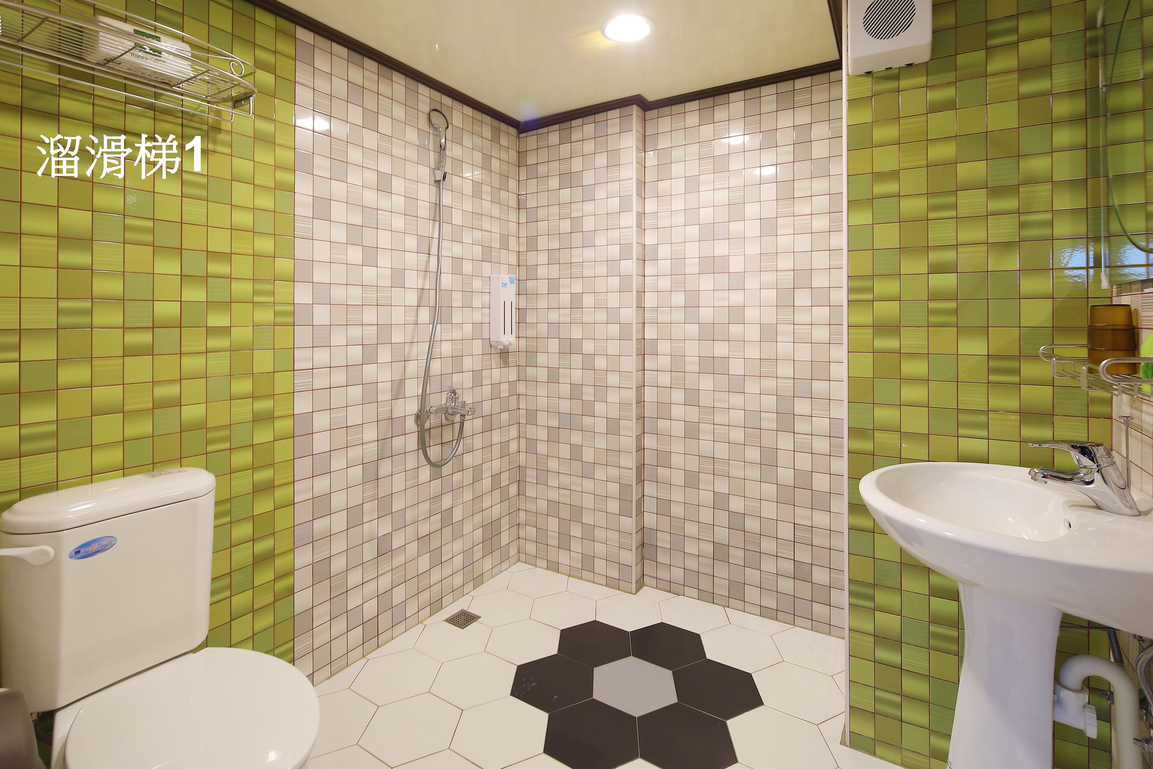 A bathroom with a toilet, shower, and sink.