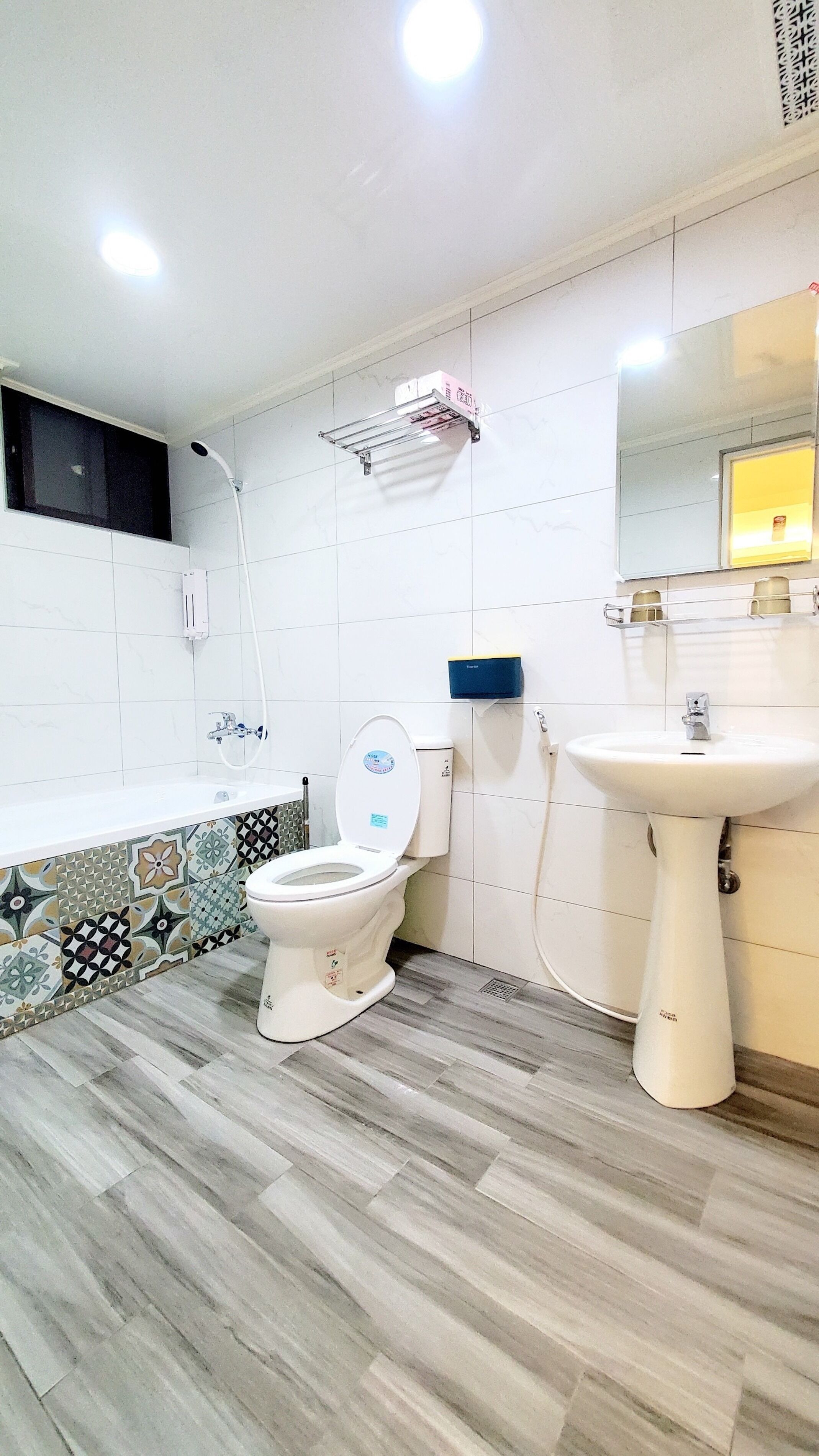 Une salle de bain comprenant des toilettes, un lavabo et un espace douche.