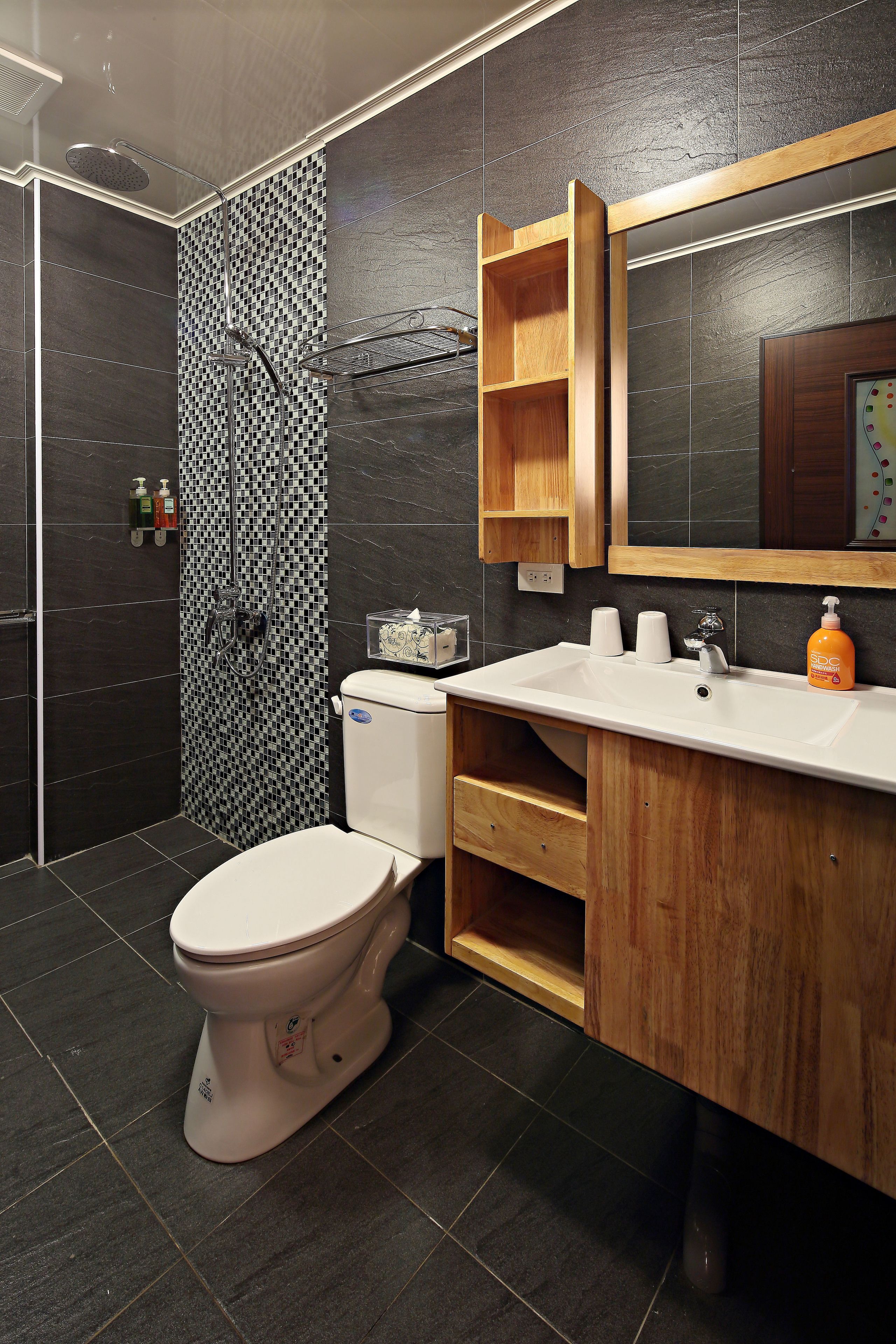 A modern bathroom with a shower, toilet, and vanity.