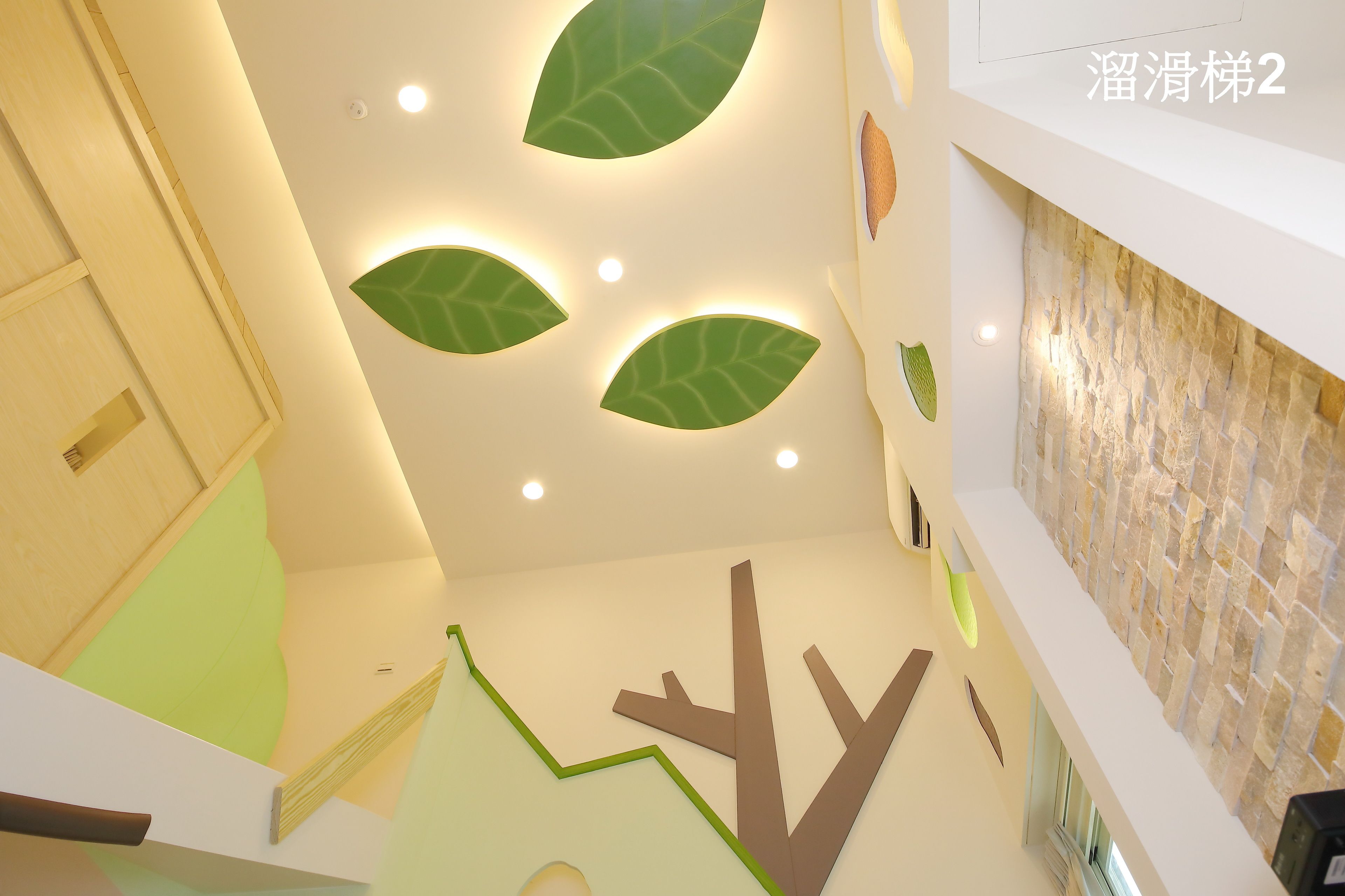 A modern interior with a wooden door, a green leaf-shaped light fixture, and a stone wall.