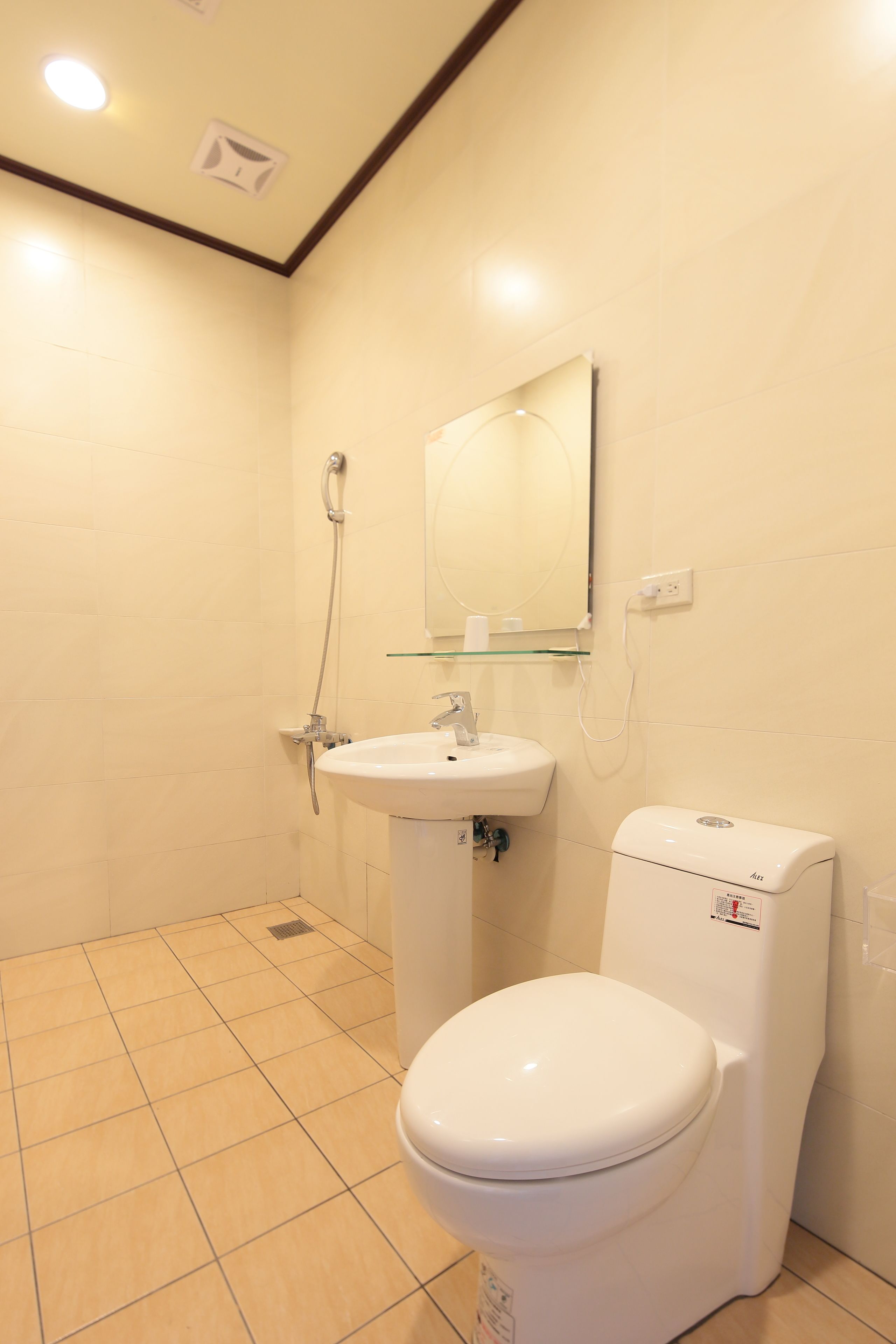 Un baño con inodoro blanco, lavamanos y ducha.