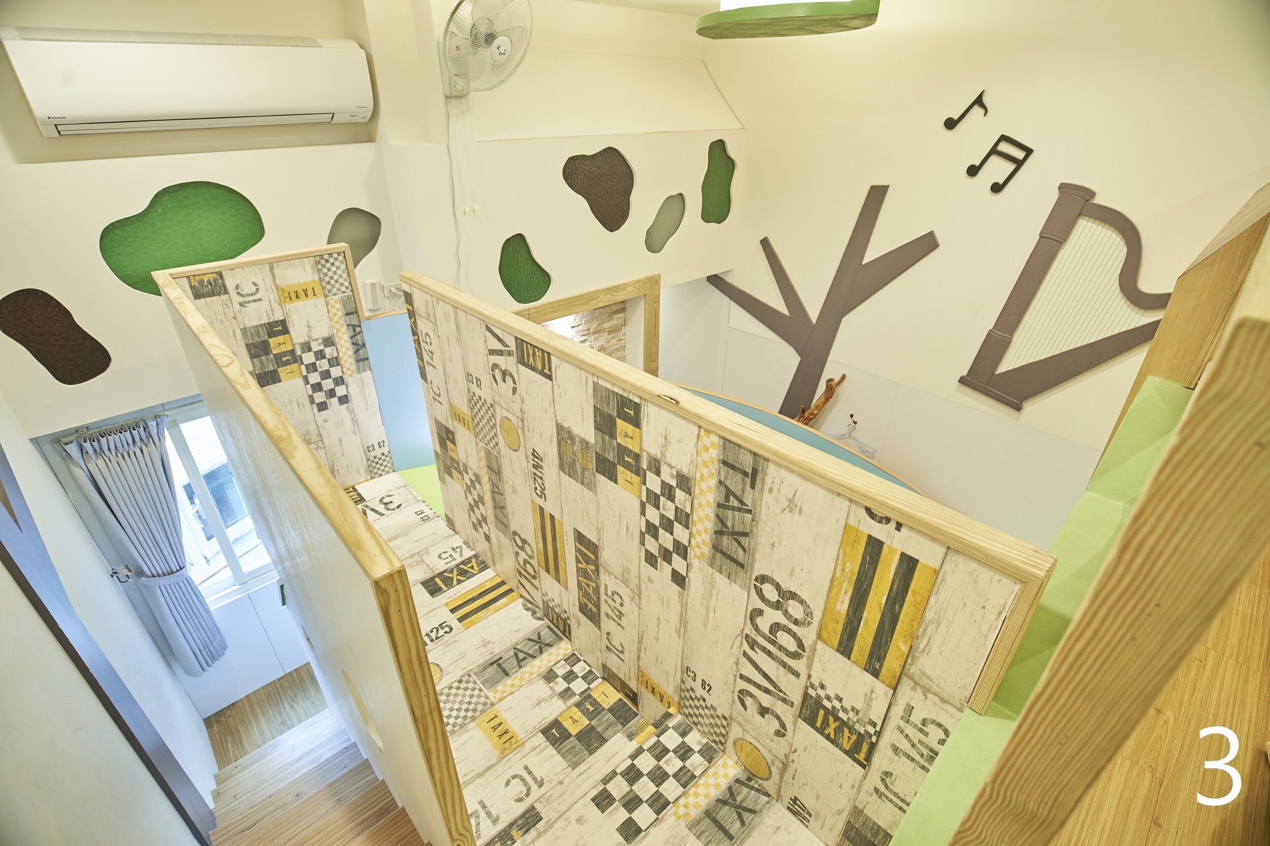 Una escalera con un suelo a cuadros y una pared decorada con formas abstractas y un diseño de árbol.