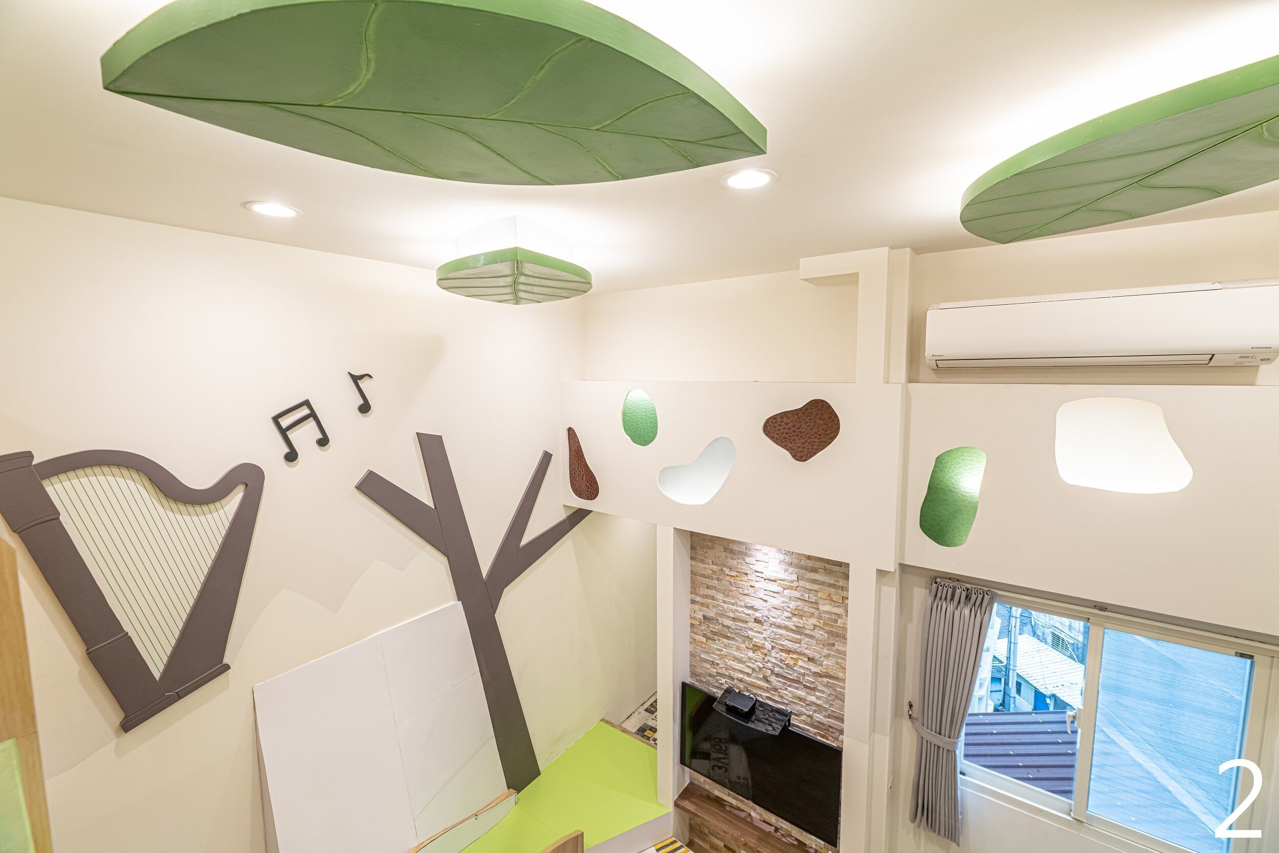 A modern interior with a harp decoration, a tree-shaped wall art, and a fireplace.