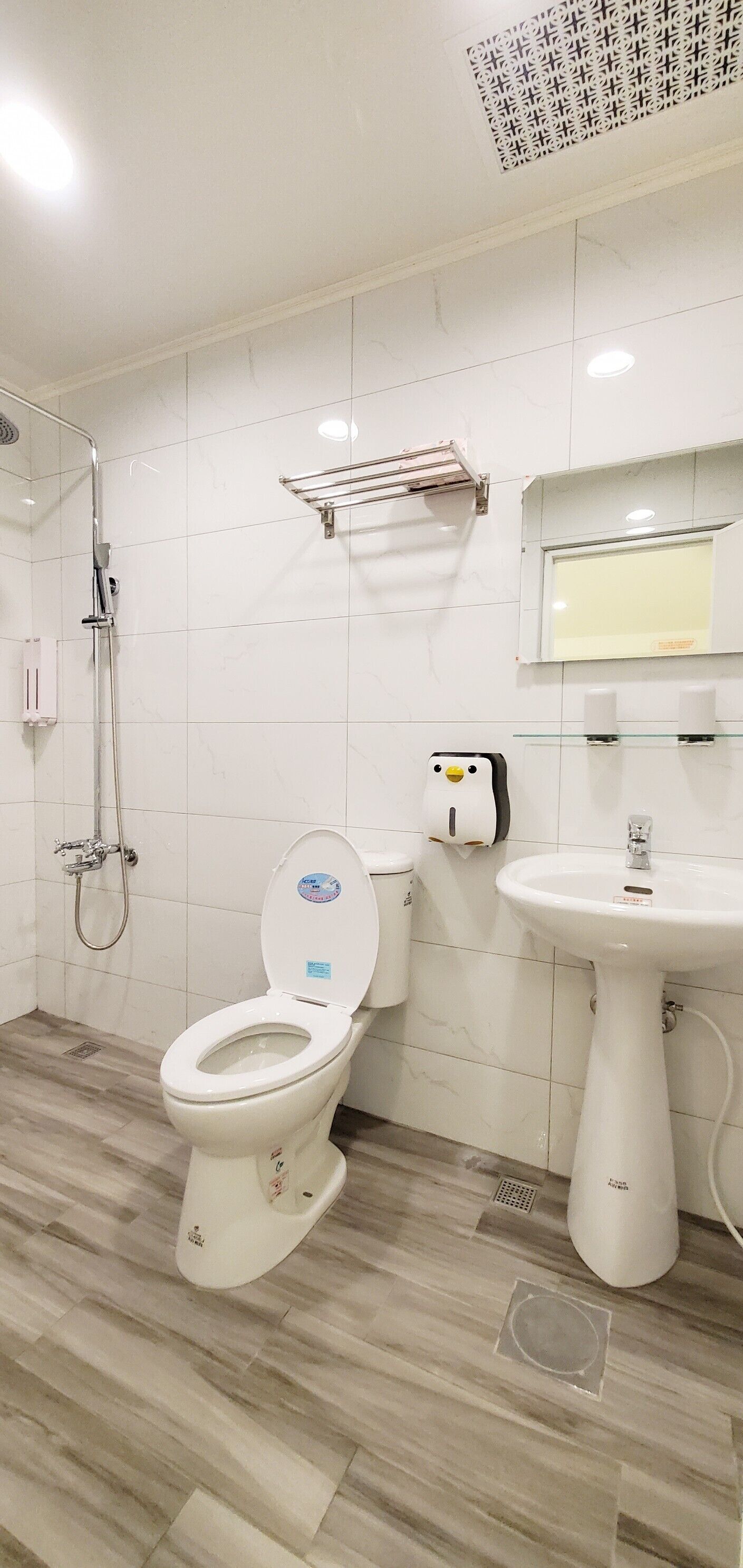 A bathroom with a toilet, sink, and shower.