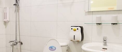 A bathroom with a toilet, sink, and shower.
