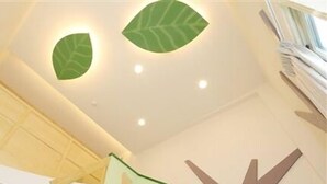 A modern interior with a unique ceiling design featuring leaf-shaped lights and geometric patterns. - Happiness Yes Inn (Luodong)