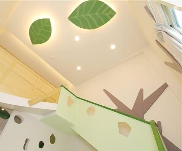 A modern interior with a unique ceiling design featuring leaf-shaped lights and geometric patterns.