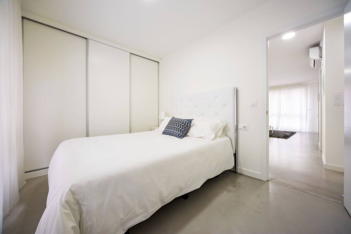 A bedroom with a bed, a pillow, and a wardrobe.